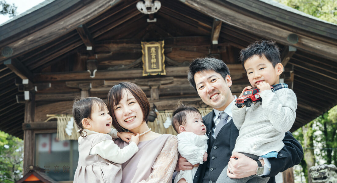 産宮神社でお宮参りの写真を撮る家族