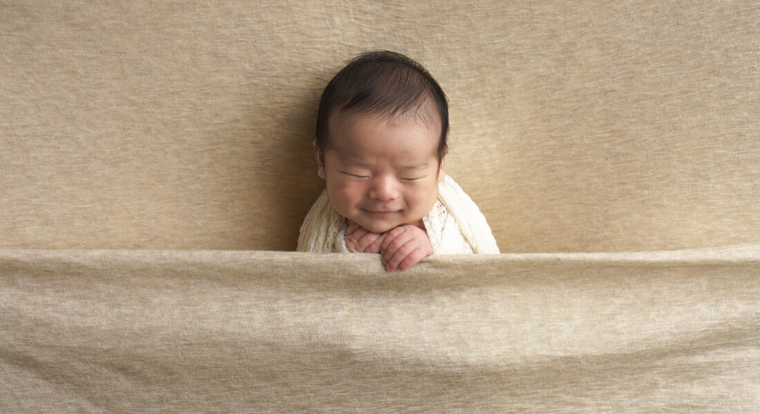 ニューボーンフォトの微笑む赤ちゃん